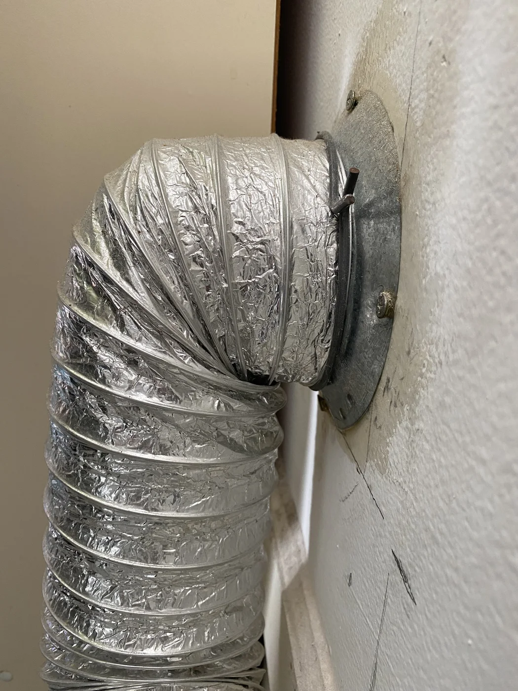 Flexible foil dryer duct making a tight bend at a metal collar