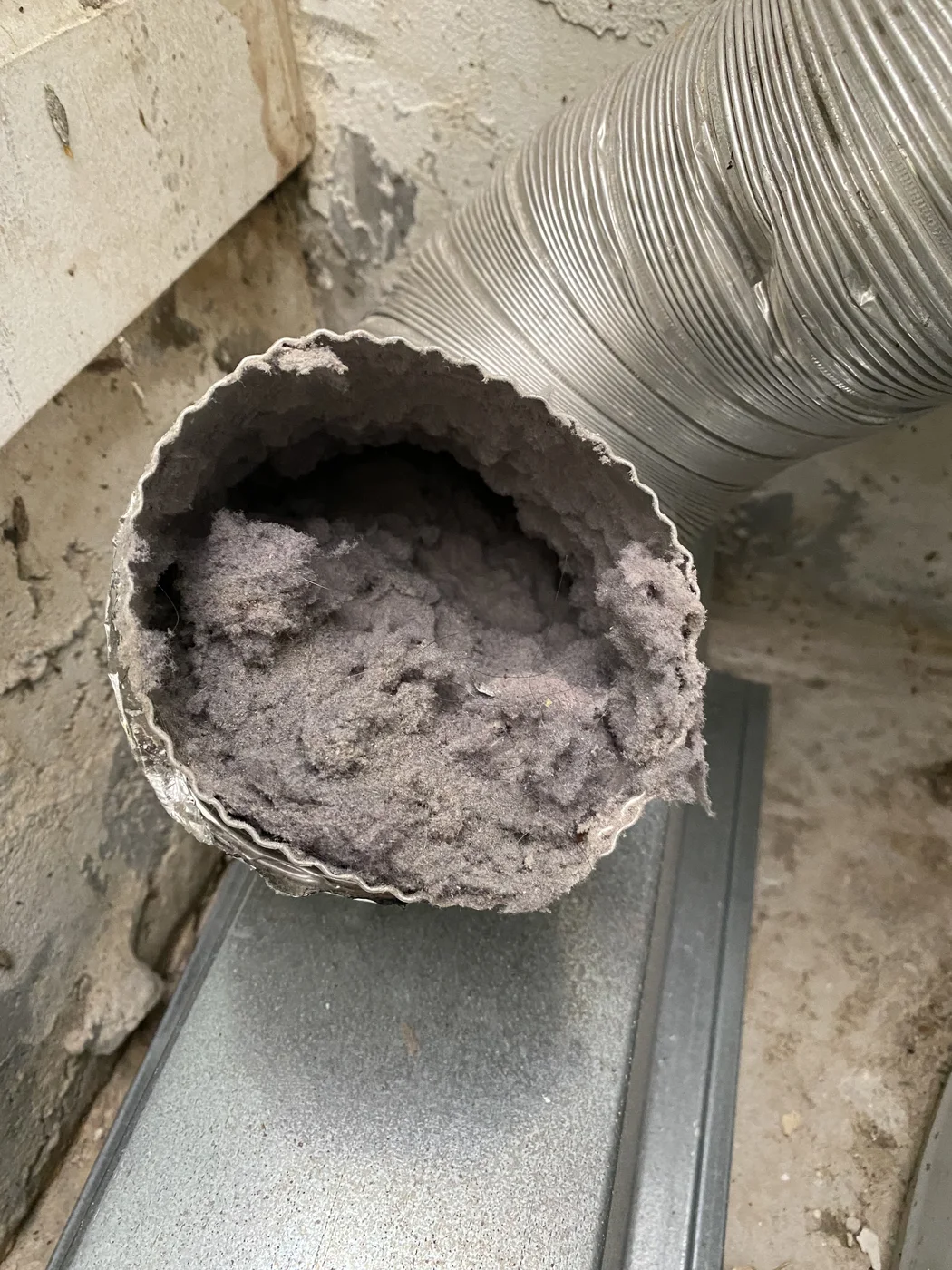 Flexible metal dryer duct opening with dense lint accumulation