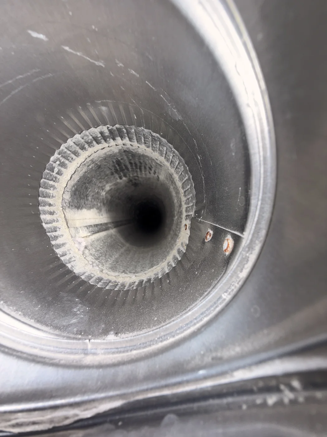 Post-service view through an accessible round metal dryer exhaust passage